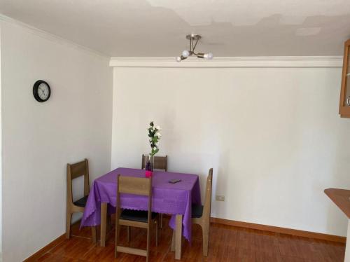 jadalnia z purpurowym stołem i krzesłami w obiekcie Departamento amoblado por día w mieście Arica