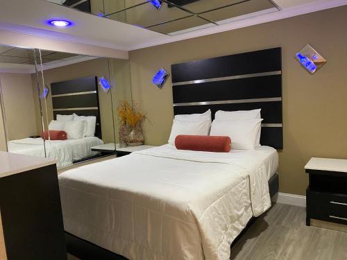 a bedroom with a large bed and a large mirror at Relax Inn North Babylon in North Babylon