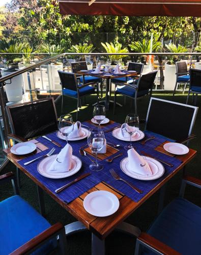 a wooden table with glasses and plates on it at Hotel Marquis Reforma in Mexico City