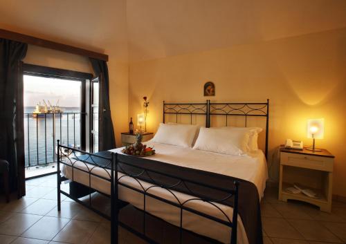 a bedroom with a large bed with a balcony at Al Pescatore Hotel & Restaurant in Gallipoli
