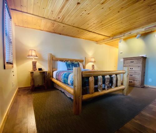 um quarto com uma cama de madeira e um tecto de madeira em Salida Inn & Monarch Suites em Salida