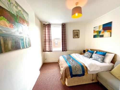 - une chambre avec un lit et un canapé dans l'établissement 4 bedroomed maisonette in City Centre, near Barbican & Seafront, à Plymouth