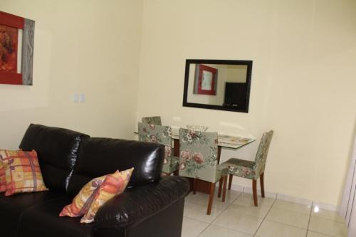 a living room with a couch and a table and a mirror at Edicula Brotas in Brotas
