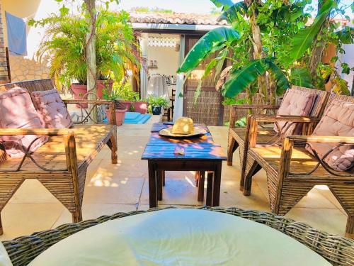 a patio with chairs and a table with a hat on it at Pousada Casa do Bruno in Canoa Quebrada