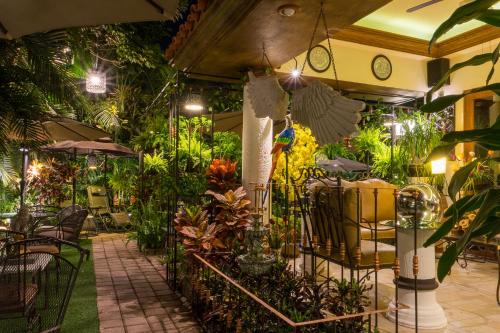 a patio with a lot of plants and tables and chairs at El Jardín del Edén B&B Boutique in Cuernavaca