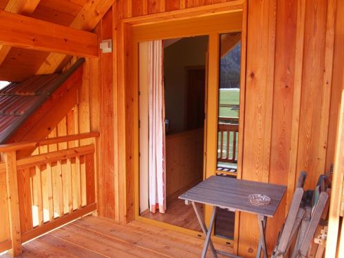 a wooden cabin with a picnic table in the doorway at Ferienwohnungen Themessl in Kirchbach