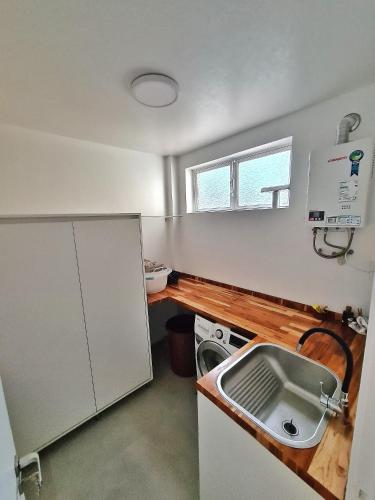 a small kitchen with a sink and a stove at Apartamento Artístico - Garagem - Ar Condicionado - Excelente Localização in Bento Gonçalves