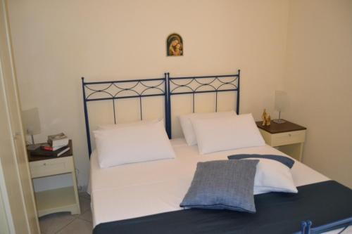 a bedroom with a bed with white sheets and pillows at Al Pescatore Hotel & Restaurant in Gallipoli