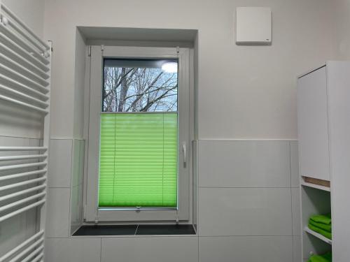 a bathroom with a window with a green window blind at Stilvoll Wohnen in Oldenburg Kreyenbrück Apartments in Oldenburg