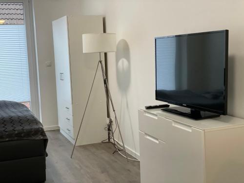 a bedroom with a television on a dresser with a lamp at Stilvoll Wohnen in Oldenburg Kreyenbrück Apartments in Oldenburg