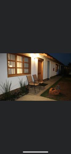 a house with two chairs and a table in front of it at Cabañas Boutique Villaseñor Pet and 420 Friendly in Huasca de Ocampo