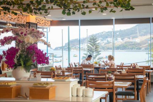 a restaurant with tables and chairs and a view of the water at Vung Tau P&T Hotel in Vung Tau