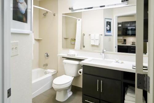 a bathroom with a toilet and a sink and a mirror at Candlewood Suites Lafayette by IHG in Lafayette