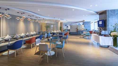 a restaurant with tables and chairs in a room at Holiday Inn Express Changsha Wuyi Plaza by IHG in Changsha