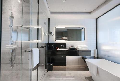 a bathroom with a glass shower and a sink at Crowne Plaza Shenzhen World Exhibition and Convention Center by IHG in Shenzhen