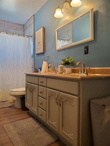 een badkamer met een wastafel en een spiegel bij Charming Clara in Yuba City