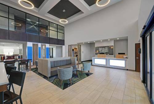 an office lobby with a couch and tables and chairs at Holiday Inn Express Newport by IHG in Newport