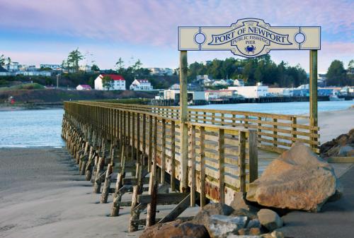 a wooden pier with a sign on the beach at Holiday Inn Express Newport by IHG in Newport