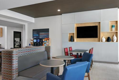 a restaurant with tables and chairs and a flat screen tv at Holiday Inn Express Newport by IHG in Newport