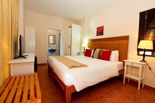 a bedroom with a large bed and a television at Roof of Africa Hotel in Windhoek