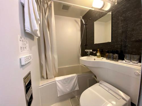 La petite salle de bains est pourvue de toilettes et d'un lavabo. dans l'établissement The CELECTON Abeno-Matsubara Ekimae, à Matsubara