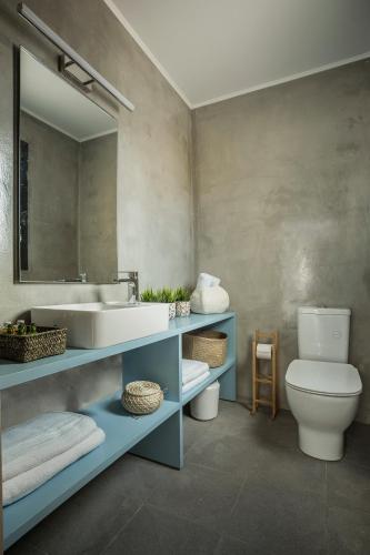 a bathroom with a sink and a toilet and a mirror at Ionian Village in Lixouri