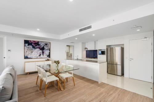 a kitchen and dining room with a glass table and chairs at Circle on Cavill - Gclr in Gold Coast