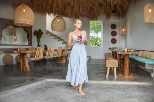 a woman in a dress standing in a room at Amar Boutique Hotel in Canggu