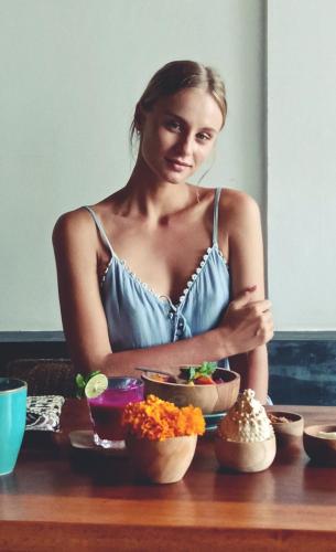 a woman sitting at a table with bowls of food at Amar Boutique Hotel in Canggu
