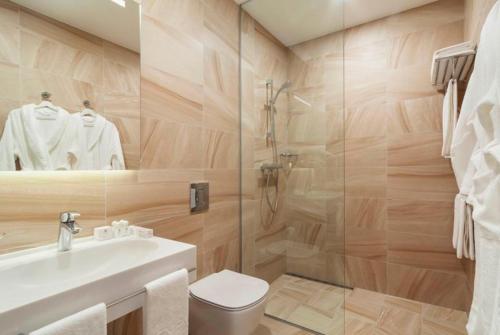 a bathroom with a shower and a toilet and a sink at Green Park Hotel in Yekaterinburg