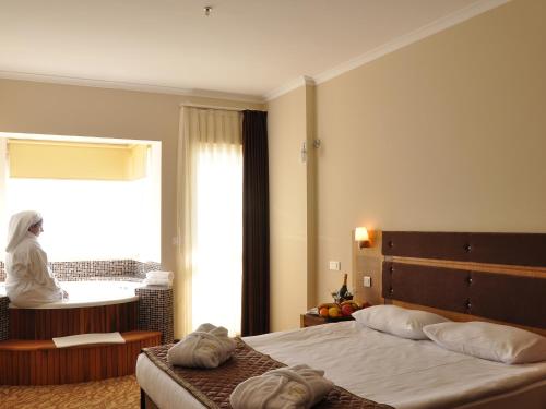 een slaapkamer met een groot bed en een raam bij İğneada Resort Hotel & SPA in Igneada
