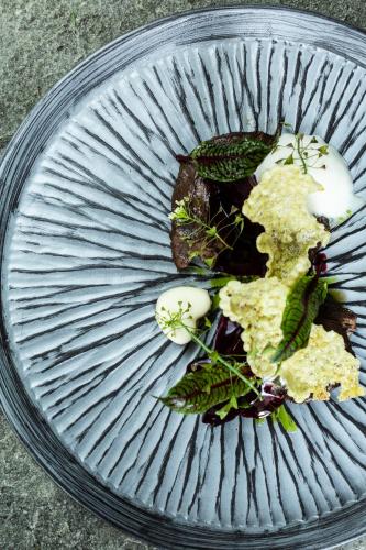 a plate with some food on top at Designhotel Sonnhof by Vitus Winkler in Sankt Veit im Pongau