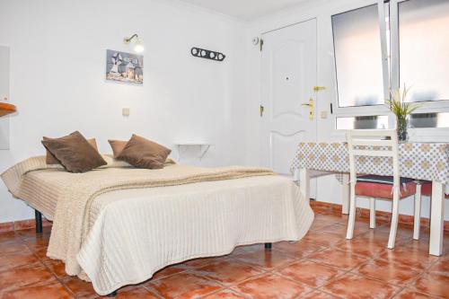a bedroom with a bed and a table and a window at Beachback Studio Apt Low-cost nearby Airport in La Garita