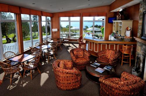a restaurant with chairs and tables and a bar at Silver Dart Lodge in Baddeck
