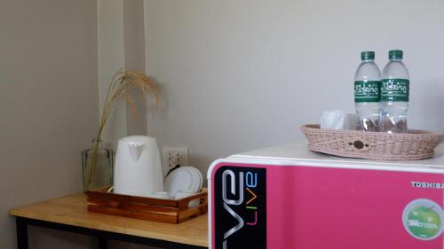 a pink refrigerator with two bottles of water on top at Resort Railumpoo (Farm and Camping) in Nakhon Sawan
