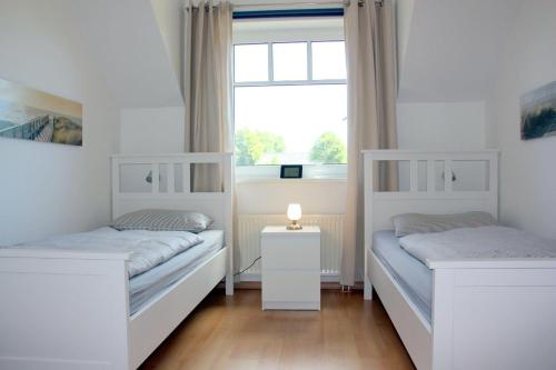 two beds in a room with a window at GODS06108-FeWo-Moeoev in Gollendorf