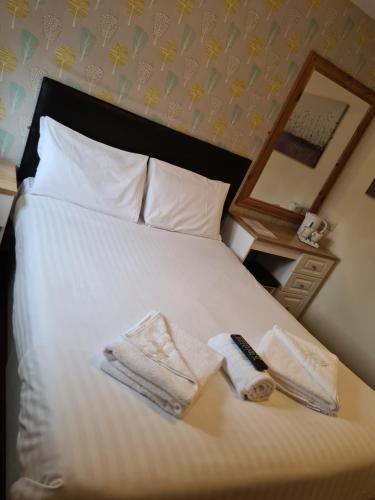 a bedroom with a bed with towels and a mirror at The Avenue Club and Lodge in Birmingham