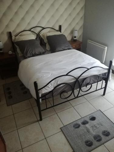a bedroom with a large bed with white sheets and pillows at Chambre d'Hôtes Spincourt 2 personnes in Spincourt