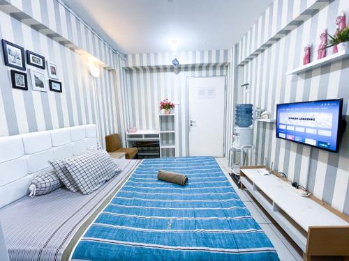 - une chambre avec un grand lit et une télévision murale dans l'établissement Green Bay Pluit Apartment - Seaview Studio Fast Wifi, à Jakarta