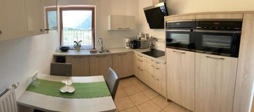 a kitchen with a table and a sink and a microwave at Haus Martina in Sand in Taufers