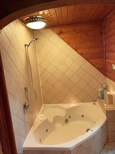 a bath tub in a bathroom with a light at Idelia at Golan Heights in Giv'at Yo'av