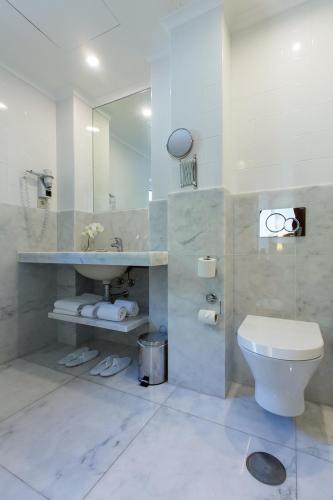 a bathroom with a toilet and a sink and a mirror at Hotel Sao Jose in Fátima