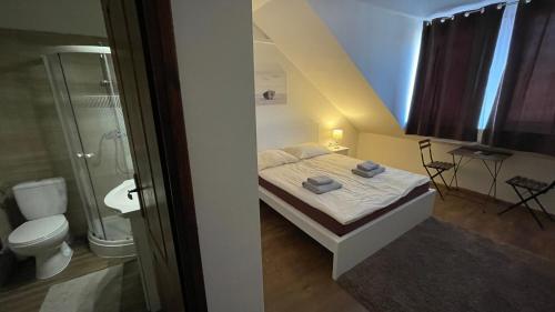 a small bedroom with a bed and a bathroom at CITY Apartman in Balatonföldvár