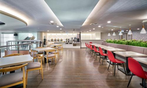 a dining room with tables and red chairs at Ho Fong Business Stay in Fengyuan