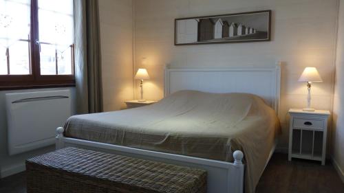 a bedroom with a bed with two tables and two lamps at La Maison Cent 5 avec parking privé in Saint-Valéry-sur-Somme