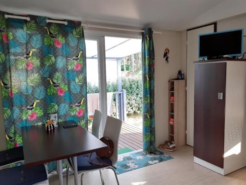 d'une salle à manger avec une table et une porte coulissante en verre. dans l'établissement mobil home, à Lacanau-Océan
