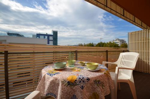 a table with two cups and oranges on a balcony at Residenza Casa Mare in Lignano Sabbiadoro