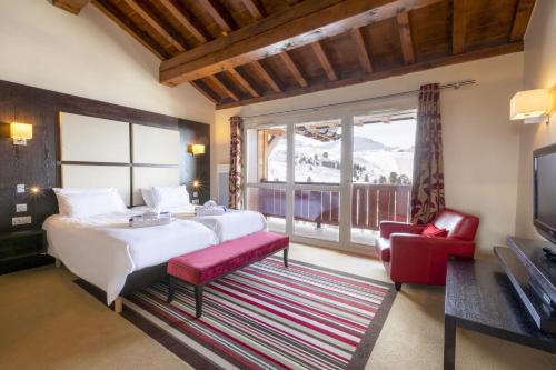 ein Schlafzimmer mit einem Bett und einem großen Fenster in der Unterkunft Hôtel Club MMV Les 2 Domaines in Belle Plagne