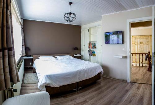 a bedroom with a large bed and a chandelier at B&B Den Boomgaard Moorsel in Moorsel