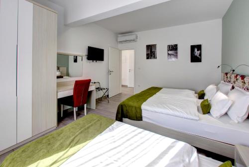 a hotel room with two beds and a desk at Villa Fortuna in Mostar